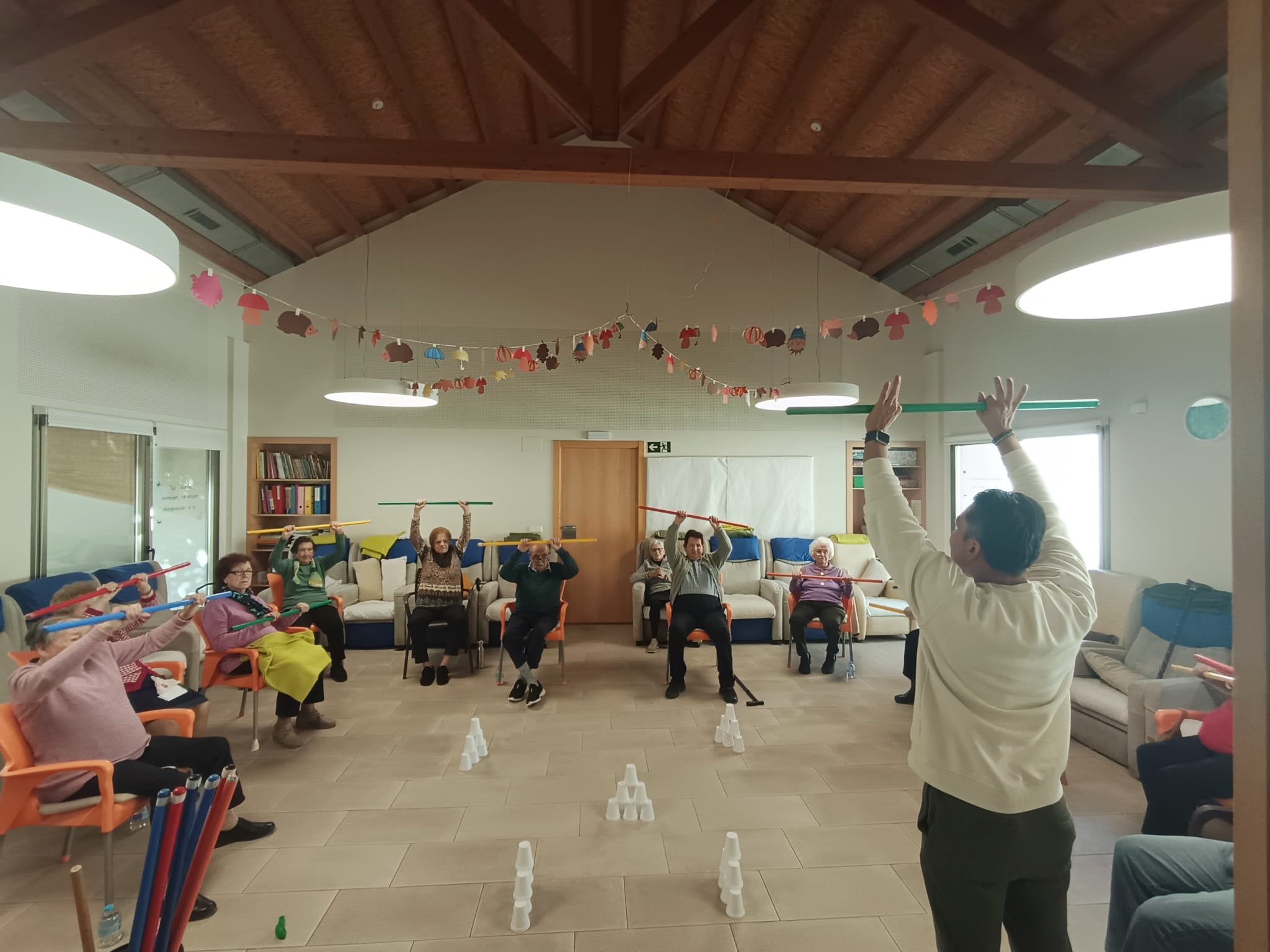 Usuarios realizando ejercicio terapéutico con barras dirigidos por un profesional en AFA Castalla y Onil.