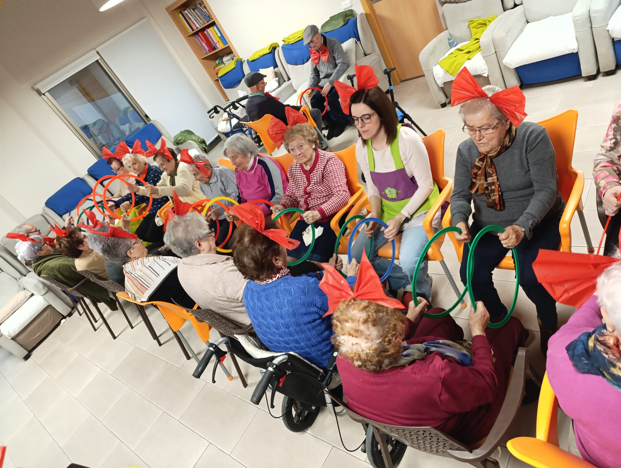 Usuarios participando en una actividad grupal con aros y lazos rojos en AFA Castalla y Onil.