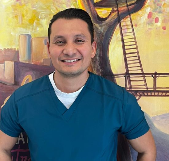 Retrato de Brahyam David Bernal García, terapeuta ocupacional en AFA Castalla y Onil, sonriendo frente a un mural artístico.