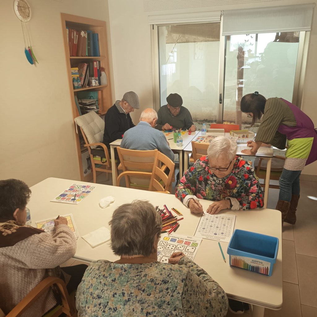 Usuarios realizando ejercicios cognitivos en grupo con supervisión profesional en AFA Castalla y Onil.