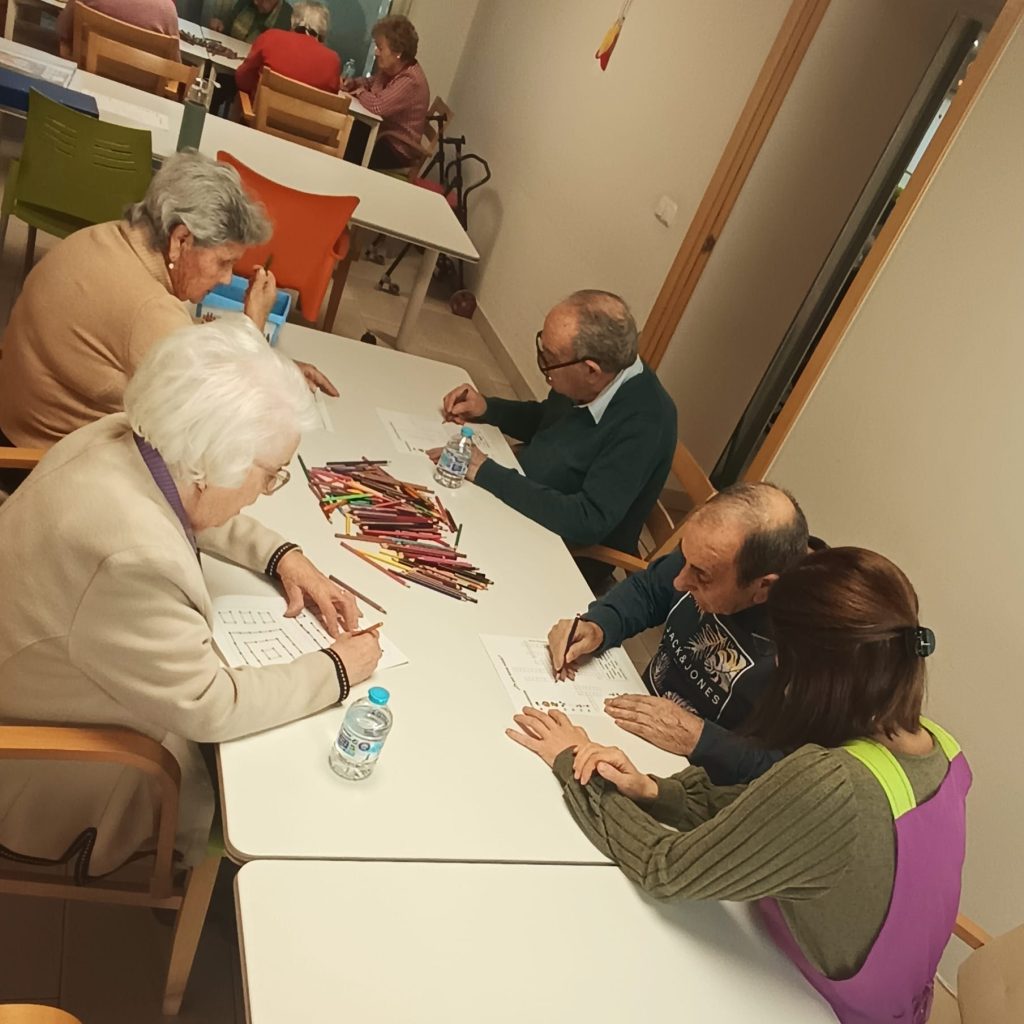 Terapeuta ocupacional ayudando a usuarios con ejercicios cognitivos en AFA Castalla y Onil.